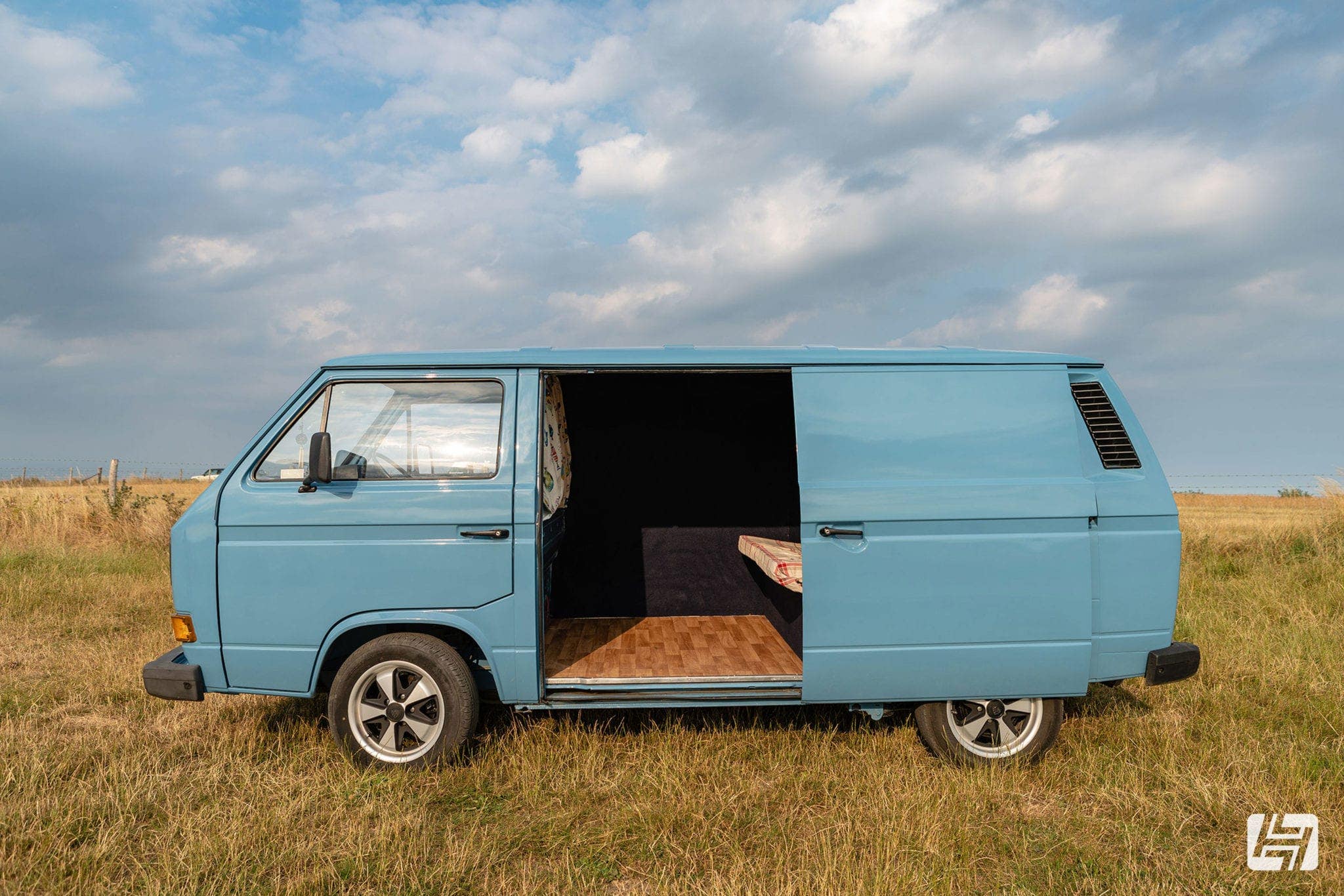 Blue VW T25 panel van side profile with sliding door open 