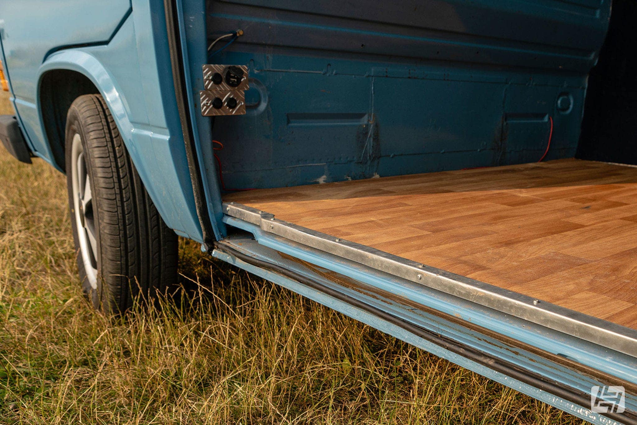 Blue VW T3 with sliding door open showing wooden floor inside