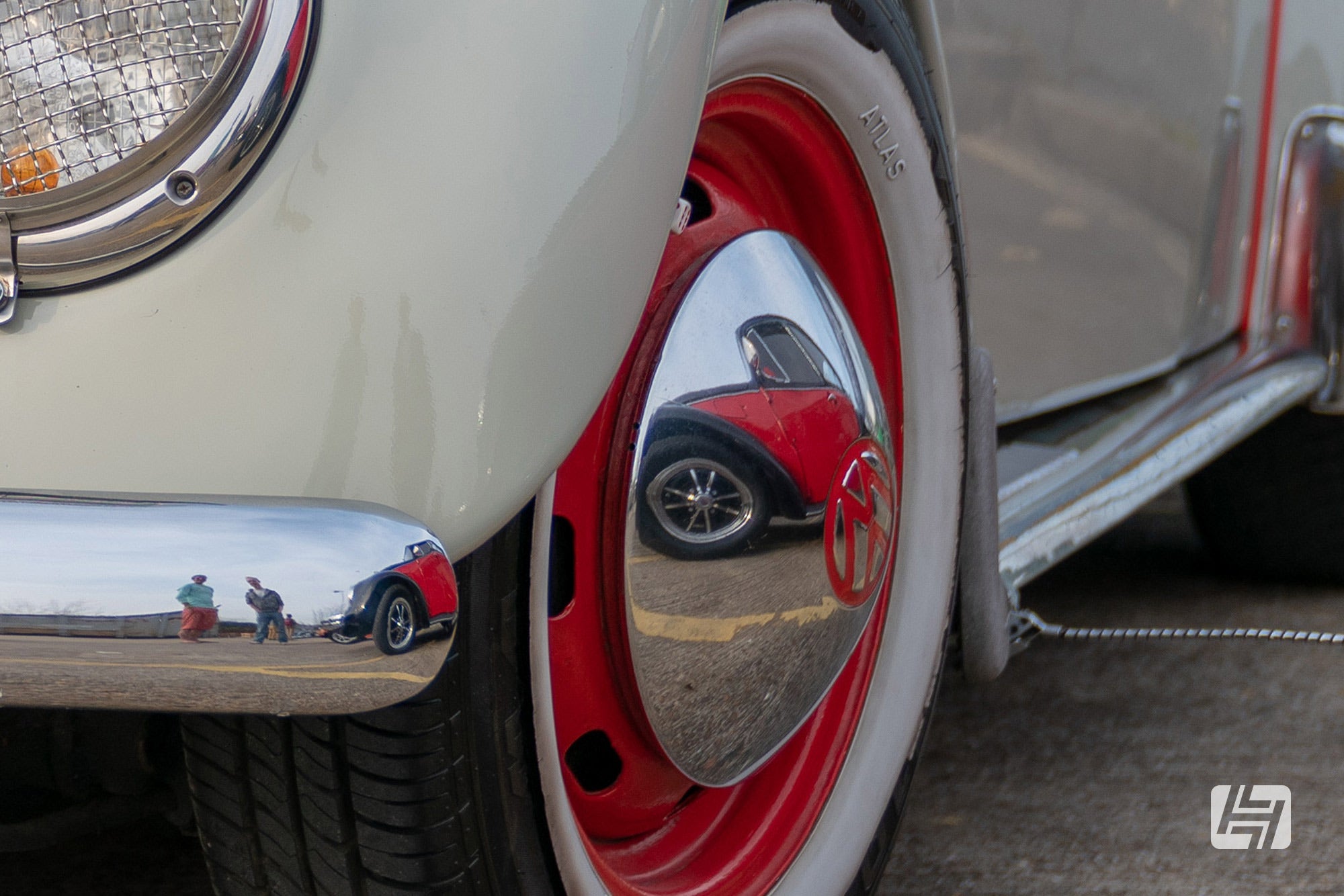 VW beetle with red steel wheels, chrome hubcaps and whitewall tyre trims