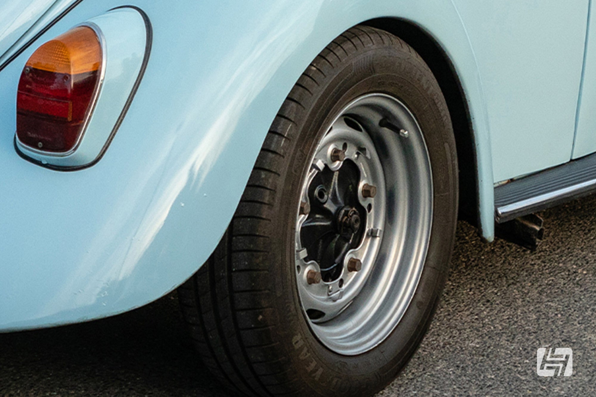 Light blue VW beetle with wide 5 steel wheels fitted without hubcaps