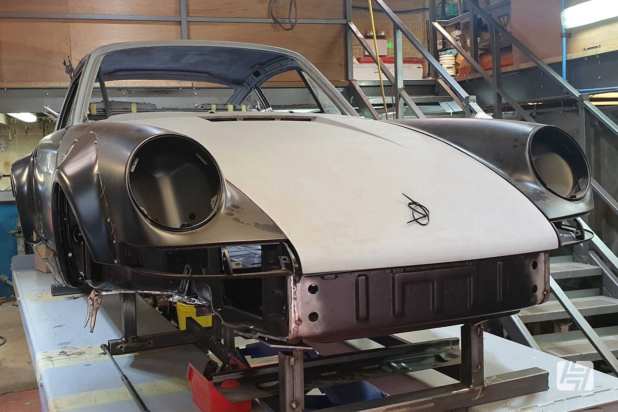 Bare shell of a Porsche 911 with wide arches being built in workshop