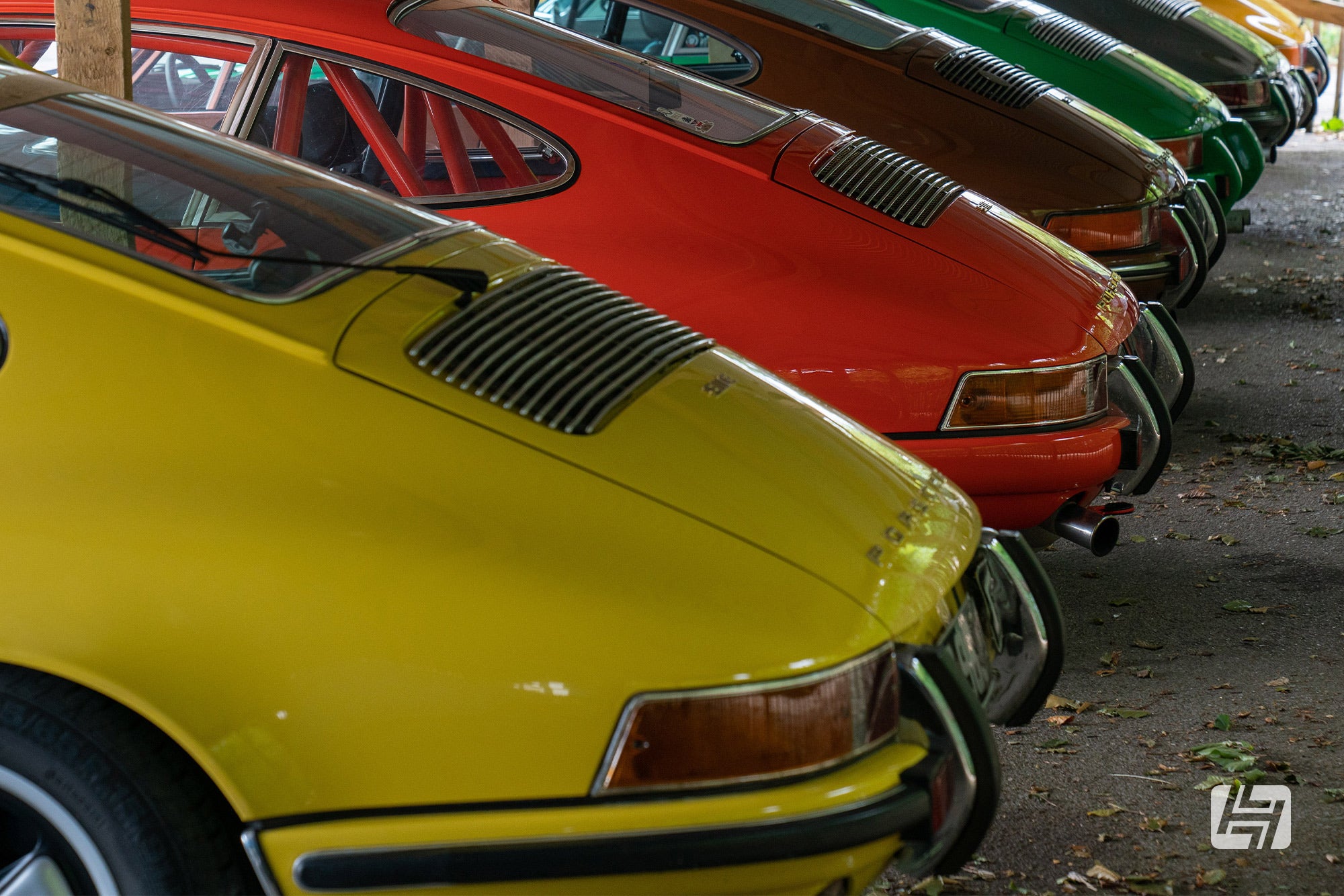 Line up of colourful classic Porsche 911 models parked at Goodwood