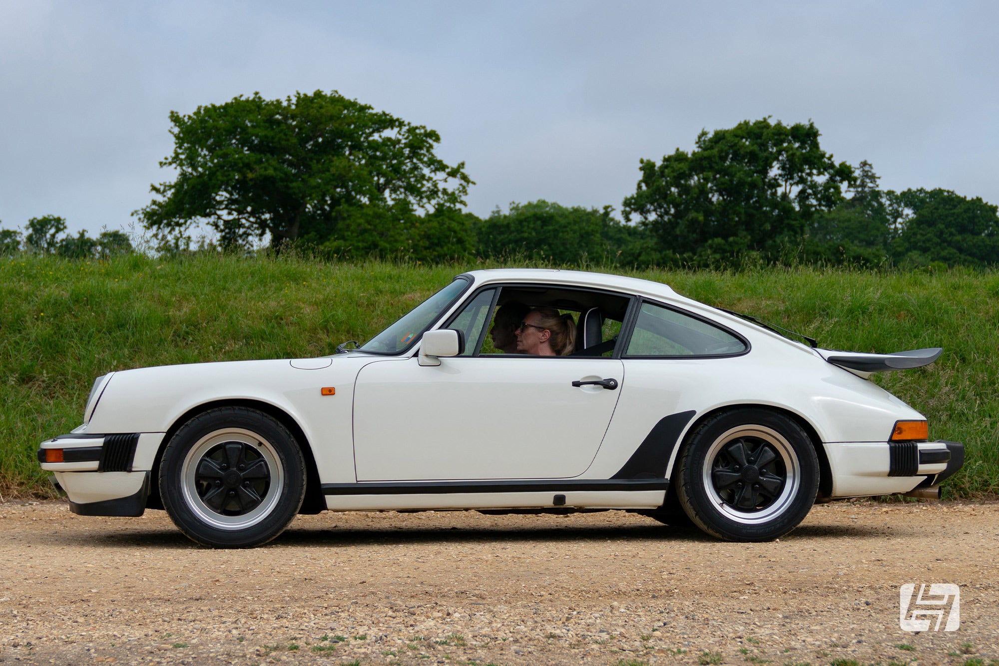 Side profile of a white Porsche 911 Carrera with whale tail rear spoiler