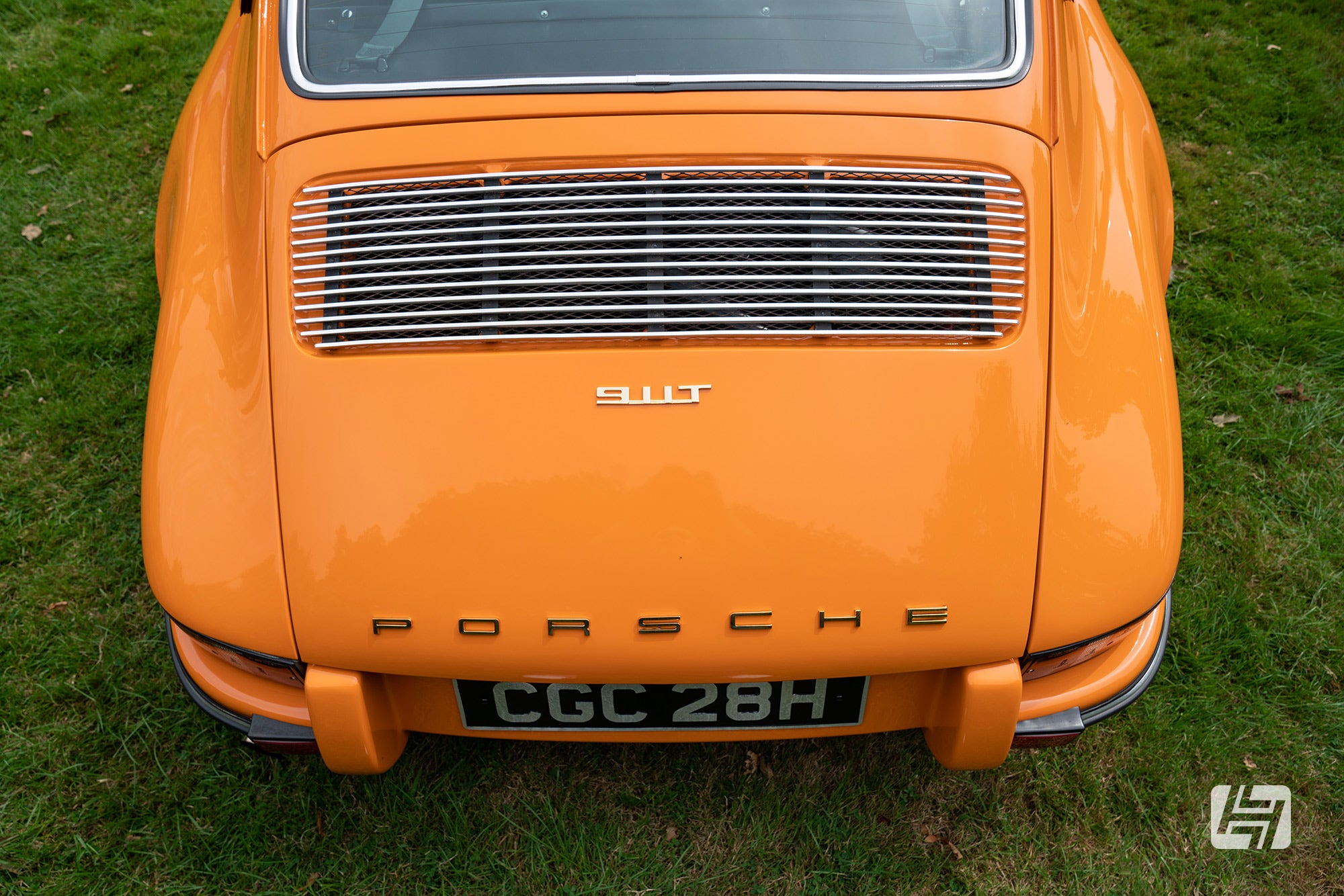 Aerial view of early orange Porsche 911 engine lid with chrome vent trims